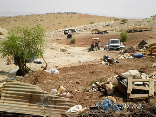 Destroyed Palestinian houses in the front, Israeli settlement in construction in the back