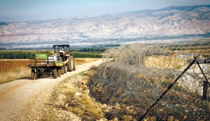 A tractor working Kibbutz Merav’s fields between the separation fence and the Green Line. Photo by: Alon Ron