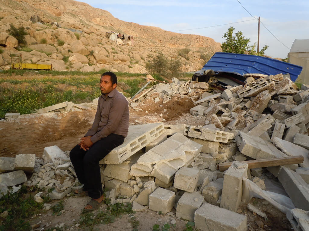 Yousef Bsharat sitting on his demolished home