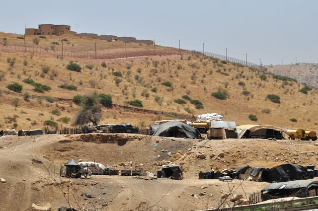 Bedouin community of Ein El Hilwe with Maskiyyot settlement towering overhead