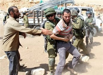 An Israeli soldier restrains a man near a truck loaded with supplies on September 20, 2013.(AFP)